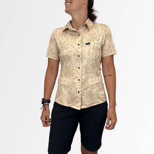 Image of the Women's Catalyst Mountain Bike Button-Down Shirt in Rhodo Tan: A high-performance jersey disguised as a stylish button-down shirt. Features a front stash pocket, built-in lens wipe, and reinforced snaps. 100% recycled with 6% Silver Ion content for natural cooling and odor control. New Tru-Fit sizing for a more feminine silhouette. UPF30 sun protection for outdoor adventures.
