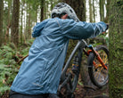 Image of Adapt Packable Mountain Bike Jacket - A versatile, ultra-lightweight, and packable cycling jacket made from 100% Rip-stop Nylon. Wind and rain resistant with Durable Water Repellent (DWR) treatment and fully taped seams to keep moisture out. Features an oversized hood for helmets, chest stash pocket, dual waist adjusters, and reflective logos for style and safety. Unisex fit, perfect for year-round mountain biking adventures.