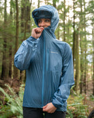 Image of Adapt Packable Mountain Bike Jacket - A versatile, ultra-lightweight, and packable cycling jacket made from 100% Rip-stop Nylon. Wind and rain resistant with Durable Water Repellent (DWR) treatment and fully taped seams to keep moisture out. Features an oversized hood for helmets, chest stash pocket, dual waist adjusters, and reflective logos for style and safety. Unisex fit, perfect for year-round mountain biking adventures.